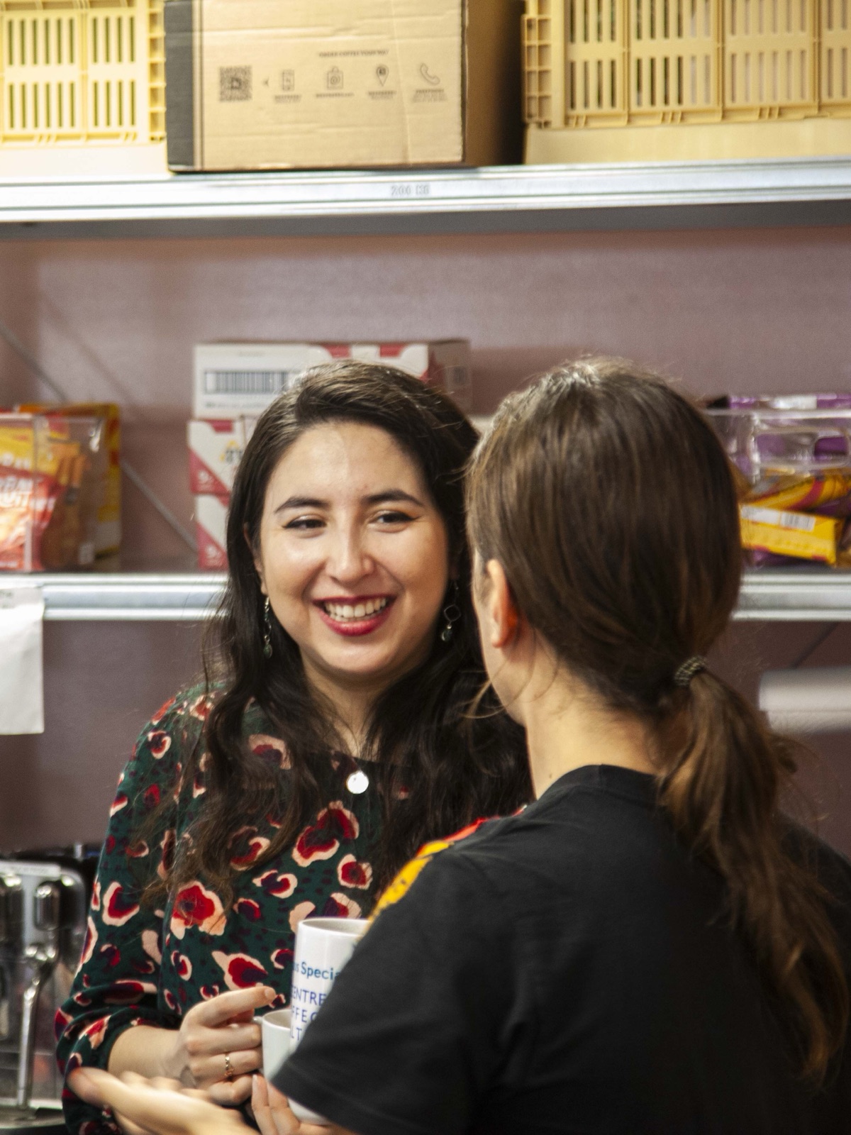 Two people chatting over tea in the Meridian office kitchen
